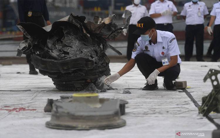 Petugas menata serpihan pesawat Sriwijaya Air SJ 182 rute Jakarta-Pontianak yang jatuh di perairan Kepulauan Seribu di Dermaga JICT, Jakarta, Senin (11/1/2021). ANTARA FOTO/Akbar Nugroho Gumay/rwa.