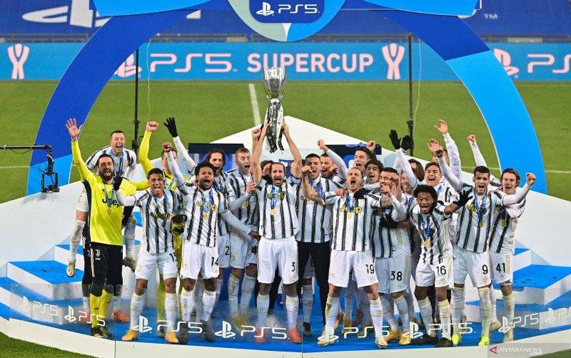 Bek Juventus Giorgio Chiellini (tengah) mengangkat trofi Piala Super Italia bersama rekan-rekan setimnya untuk merayakan keberhasilan mereka mengalahkan Napoli dengan skor 2-0 pada pertandingan yang dimainkan di Stadion Mapei, Sassuolo, Rabu (20/1/2021). (foto : ANTARA/AFP/MIGUEL MEDINA)
