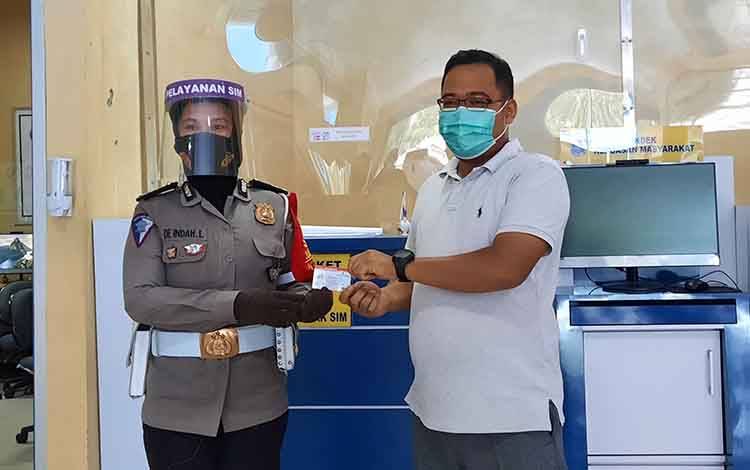 Petugas Satlantas Polres Kobar menyerahkan blangko SIM kepada pemohon.