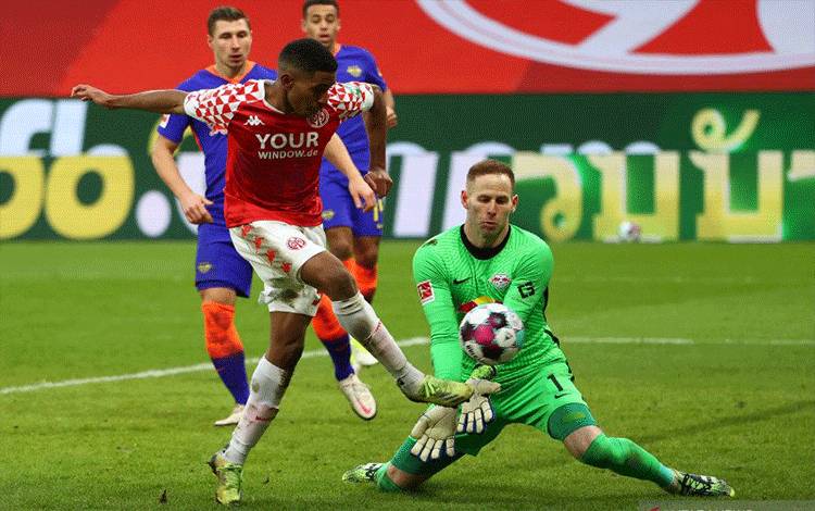 Gelandang Mainz 05 Leandro Barreiro Martins (kiri) berduel dengan kiper RB Leipzig Peter Gulacsi sebelum mencetak gol penentu kemenangan pada pertandingan Liga Jerman yang dimainkan di Mainz, Sabtu (23/1/2021). (ANTARA/AFP/KAI PFAFFENBACH)