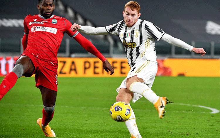 Penyerang Juventus Dejan Kulusevski (kanan) menendang bola sambil dikawal bek SPAL Caleb Okoli pada pertandingan perempat final Piala Italia yang dimainkan di Stadion Allianz, Turin, Rabu (27/1/2021). (ANTARA/AFP/ISABELLA BONOTTO)