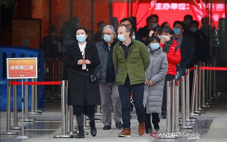 Anggota Organisasi Kesehatan Dunia (WHO) yang bertugas menyelidiki asal-usul pandemi penyakit virus corona (COVID-19), meninggalkan pameran tentang bagaimana Tiongkok memerangi virus corona di Wuhan, provinsi Hubei, China (30/1/2021). ANTARA/REUTERS/Thomas Peter/aa. (REUTERS/THOMAS PETER)