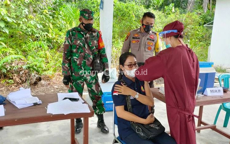 Babinsa Koramil 1016-03 Sepang Serka Helprit bersama dengan Bhabinkamtibmas Polsek Sepang Bripka Sias Hartikoe saat mendampingi vaksinasi di UPT Puskesmas Kampuri.