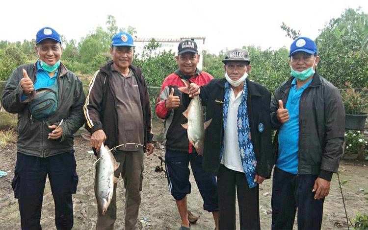 Camat Kapuas Kuala, Inop (dua dari kiri) saat mengunjungi tempat budidaya ikan di kecamatan setempat.