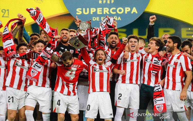 Pemain Ahtletico Bilbao Iker Muniain dan rekan setim merayakan kemenangan bersama piala mereka setelah menjuarai Piala Super Spanyol mengalahkan FC Barcelona dengan skor terakhir 3-2, di Estadio La Cartuja de Sevilla, Sevilla, Spanyol, Minggu (17/1/2021). Pablo Garcia/RFEF/Handout REUTERS/AWW/djo