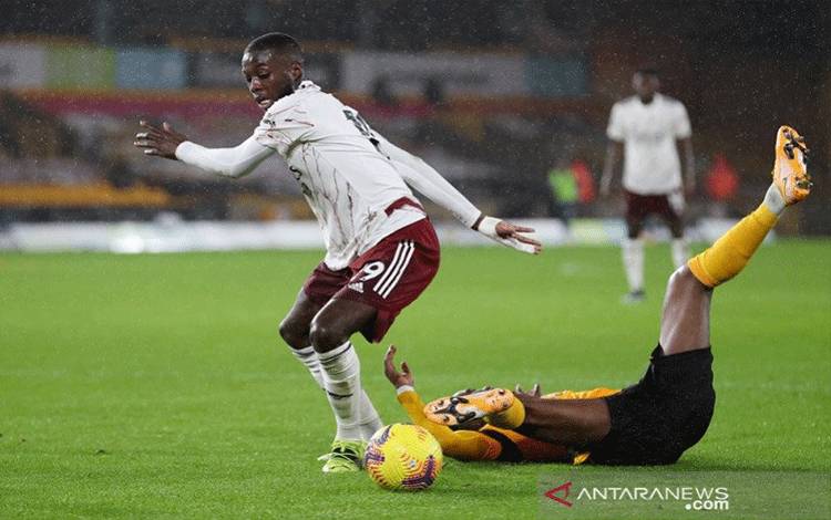 Pemain sayap Arsenal Nicolas Pepe (kiri) memenangi perebutan bola dengan bek Wolverhampton Nelson Semedo dalam lanjutan Liga Inggris di Stadion Molineux, Wolverhampton, Inggris, Selasa (2/2/2021). (ANTARA/REUTERS/POOL/Catherine Ivill)