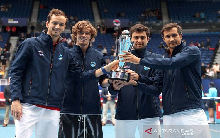 Tim Rusia Daniil Medvedev, Andrey Rublev, Aslan Karatsev dan Evgeny Donskoy merayakan kemenangan pada ATP Cup dengan trofi setelah mengalahkan Tim Italia di Melbourne Park, Melbourne, Australia, Minggu (7/2/2021). (REUTERS/Loren Elliott TPX IMAGES OF THE DAY)