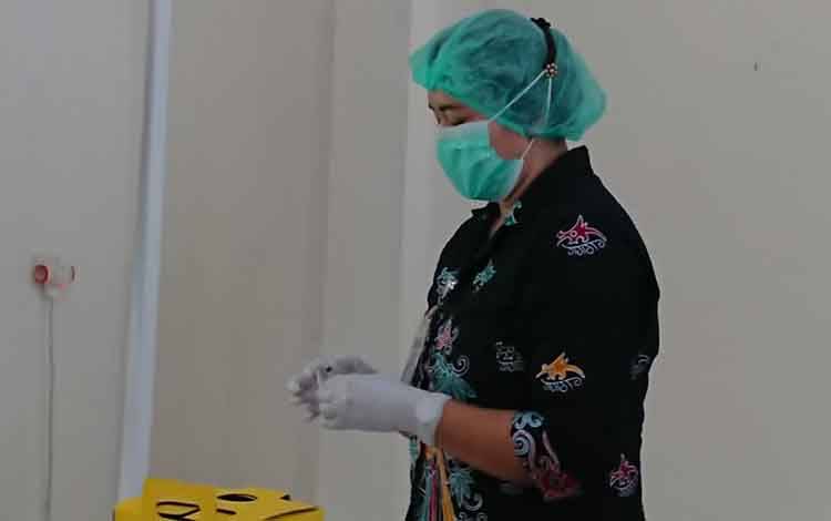 Vaksinator sedang menyiapkan vaksin sebelum disuntikan.