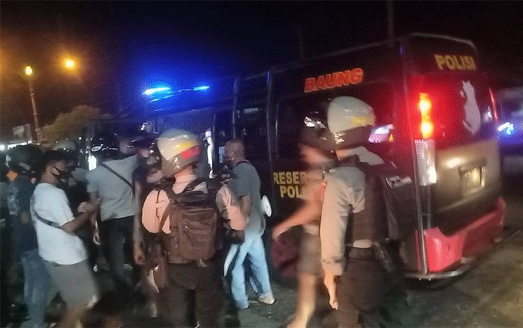 Kedua pria yang terlibat perkelahian saat digiring ke mobil anggota Polda Kalteng.