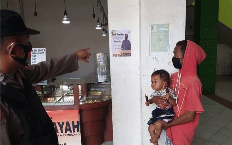Personel Polsek Seruyan Hilir saat menempelkan selebaran berisi nomor telepon layanan pengaduan agar diketahui oleh masyarakat.