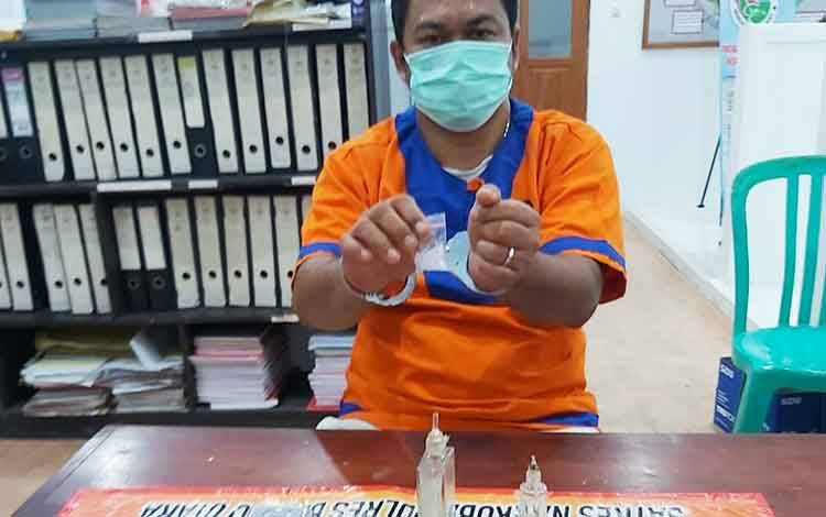 Norman beserta barang bukti saat diamankan di ruangan Satresnarkoba Polres Barito Utara untuk proses penyelidikan lebih lanjut.