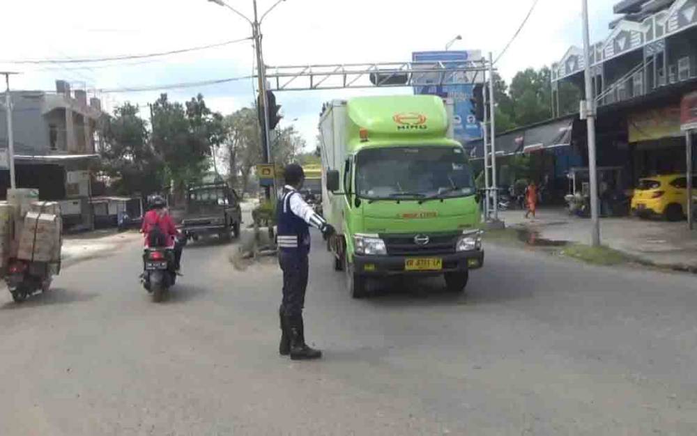 Pegawai Dishub saat mengatur angkutan truk agar tidak melintas di jalan dalam kota yang dilarang.?