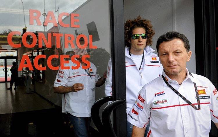 Pebalap Italia Marco Simoncelli (kiri) dan manajer tim Fausto Gresini meninggalkan ruang race control setelah menyatakan tabrakan dengan Dani Pedrosa di Grand Prix Catalunya, Montmelo, Barcelona. (2/6/2011) (AFP Photo/Lluis Gene)