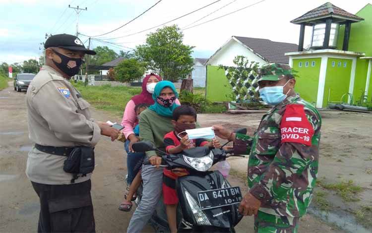 Babinsa Bersama Kelurahan Sabaru Konsisten Edukasi dan Bagikan Masker di Posko PPKM Mikro