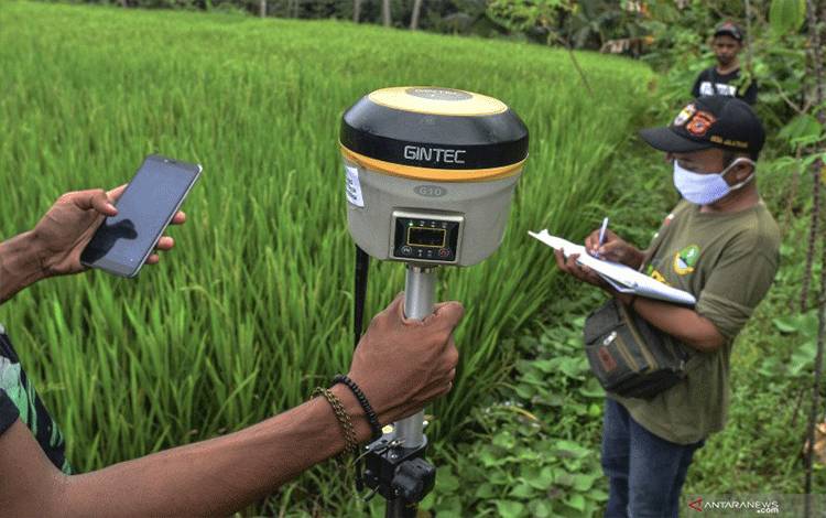 Petugas mengukur bidang tanah milik warga melalui program Pendaftaran Tanah Sistematis Lengkap (PTSL) melalui Pemerintah Desa Jalatrang di Kecamatan Cipaku, Kabupaten Ciamis, Jawa Barat. ANTARA FOTO/Adeng Bustomi/wsj. (ANTARA FOTO/ADENG BUSTOMI)