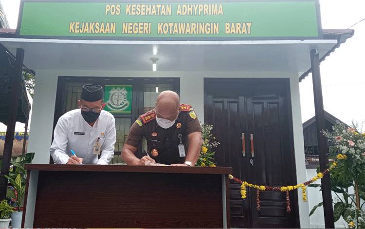 Kajari Kobar Dandeni Herdiana dan Kadinkes Kobar Achmad Rois saat menandatangani MoU dalam peresmian Pos Kesehatan Adhiprima di Kantor Kejari Kobar, Rabu, 3 Maret 2021.