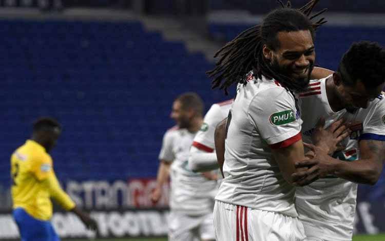 Bek Lyon asal Belgia, Jason Denayer (kiri), merayakan gol yang membuat timnya lolos ke 16 Besar Piala Prancis setelah menaklukkan Sochaux di Stadion Groupama di Decines-Charpieu, dekat Lyon, Prancis, pada 6 Maret 2021