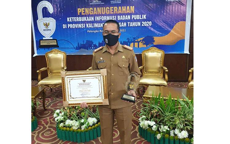 Sekda Mura Drs. Hemon saat menerima penghargaan keterbukaan informasi publik.