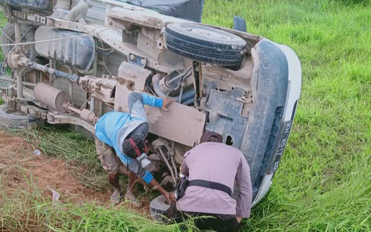 Anggota Polsek Kolam membantu evakuasi mobil pikap angku sayur terbalik