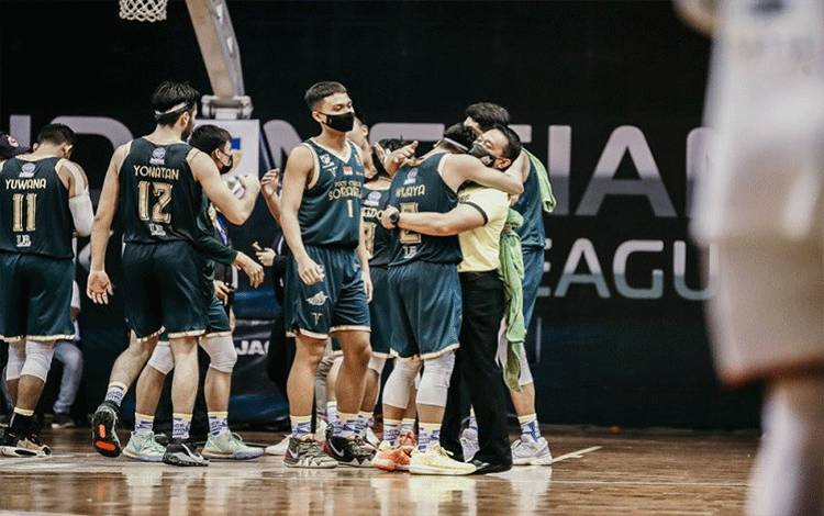 Pelatih kepala Pacific Caesar Surabaya Aries Herman (kanan) melakukan selebrasi bersama para pemainnya selepas memetik kemenangan perdana musim ini dalam lanjutan Seri II IBL 2021 melawan NSH Moutain Gold Timika di gelembung Robinson Resort, Bogor, Jawa Barat, Selasa (23/3/2021). (HO/IBL/Ariya Hoedajanto)