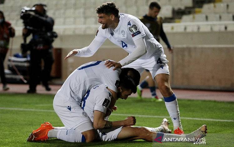 Pemain sayap tim nasional Siprus Ioannis Pittas (tengah bawah) melakukan selebrasi bersama rekan-rekannya seusai mencetak gol ke gawang Slovenia dalam lanjutan kualifikasi Piala Dunia 2022 zona Eropa Grup H di Stadion GSP, Nicosia, Siprus, Selasa (30/3/2021) waktu setempat. (ANTARA/REUTERS/Yiannis Kourtoglou)
