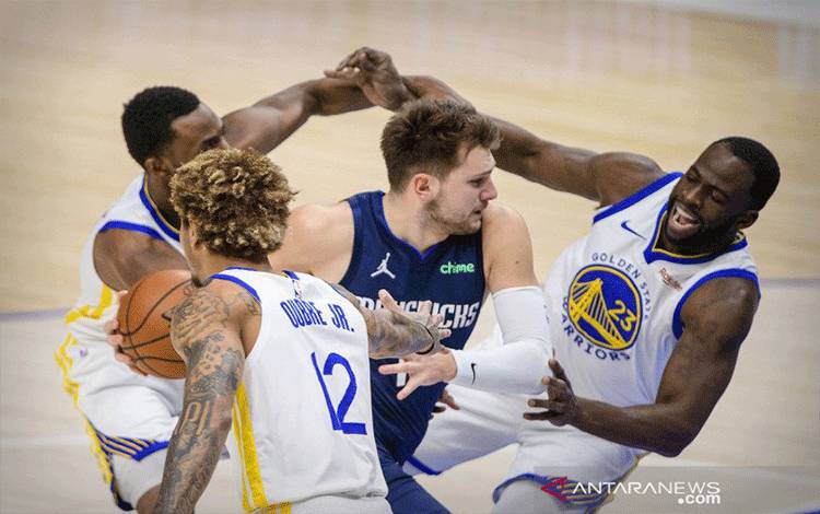 Arsip - Pebasket Dallas Mavericks Luka Doncic (77) melakukan lemparan ke keranjang melewati Andrew Wiggins (22) Golden State Warriors dan Kelly Oubre Jr. (12) dan Draymond Green (23) selama kuarter pertama di American Airlines Center, Dallas, Texas, AS, Sabtu (6/2/2021). ANTARA FOTO/Jerome Miron-USA TODAY Sports/AWW/sa.