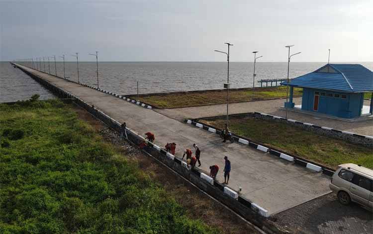Masyarakat yang mengikuti program Padat Karya saat melakukan pengecatan di kawasan Pelabuhan Teluk Segintung