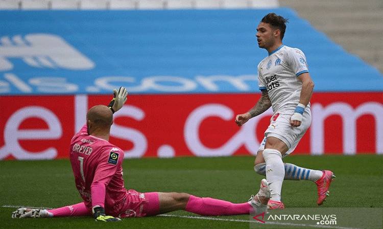 Bek sayap Marseille Pol Lirola (kanan) memperdaya kiper Lorient Matthieu Dreyer untuk mencetak gol dalam lanjutan Liga Prancis di Stadion Velodrome, Marseille, Prancis, Sabtu (17/4/2021). (ANTARA/AFP/Christophe Simon)