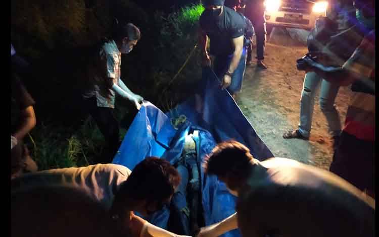Sejumlah petugas saat mengevakuasi jasad pria di semak-semak bersama motornya.