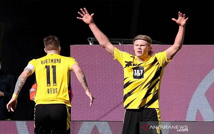 Penyerang Borussia Dortmund Erling Haaland (kanan) melakukan selebrasi seusai mencetak gol keduanya ke gawang VfL Wolfsburg dalam lanjutan Liga Jerman di Stadion Volkswagen Arena, Wolfsburg, Jerman, Sabtu (24/4/2021). (ANTARA/REUTERS/POOL/Ronny Hartmann)