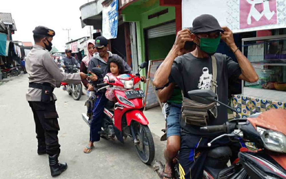 Polsek Kapuas Tengah Ingatkan Prokes Sambil Bagikan Masker untuk Warga
