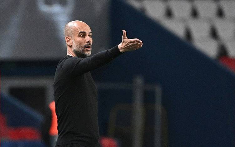 Manajer Manchester City Pep Guardiola memberikan instruksi kepada timnya dalam leg pertama semifinal Liga Champions melawan Paris Saint-Germain di Stadion Parc des Princes, Paris, 28 April 2021. (AFP/ANNE-CHRISTINE POUJOULAT)