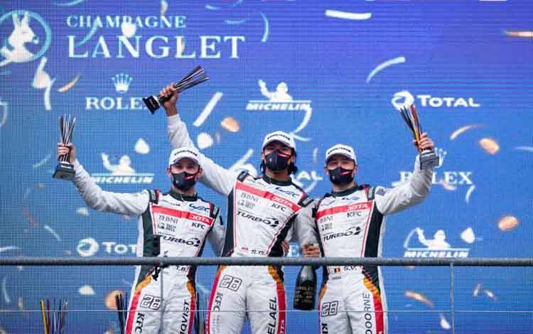 Pebalap Indonesia Sean Gelael (tengah) bersama dengan dua rekan satu timnya mengangkat trofi usai menduduki posisi ketiga FIA World Endurance Championship (WEC) di Sirkuit Spa Franchorchams, Belgia, Sabtu (1/5/2021) waktu setempat