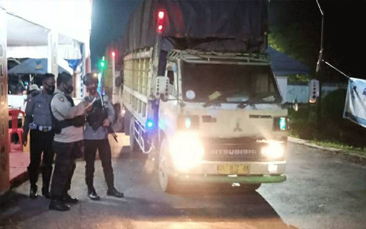 Petugas Pos Penyekatan Perbatasan Kalteng - Kalsel di Jalan Trans Kalimantan KM 12,5 Kecamatan Kapuas Timur memeriksa dokumen sopir angkutan.