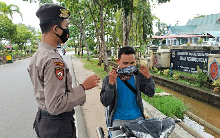 Anggota On Call Bravo Polres Kapuas Bagikan Masker ke Pengendara