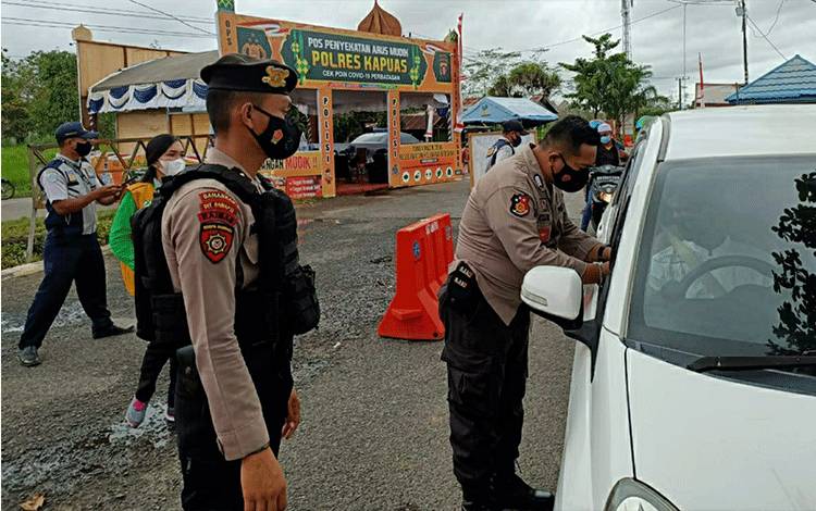 Petugas pos penyekatan arus mudik saat mengecek kelengkapan dokumen pengendara di Kecamatan Kapuas Timur.