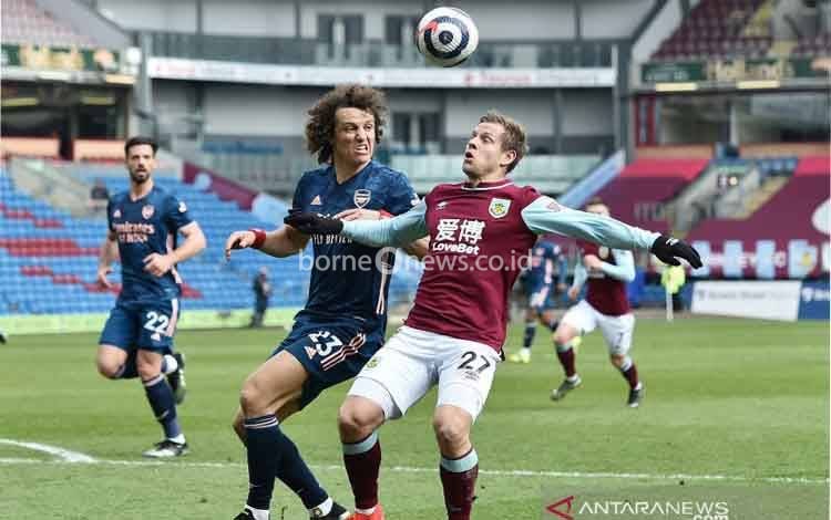 Pemain Arsenal David Luiz berebut bola dengan pemain Burnley Matej Vydra pada laga Liga Inggris di Turf Moor, Burnley, Inggris (6/3/2021)