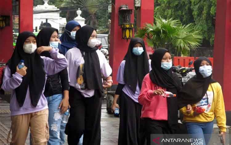 Warga menggunakan masker saat melintasi Jalan Surya Kencana, Kota Bogor, Jawa Barat, Minggu (7/2/2021). Data statistik Johns Hopkins University Medicine mencatat Indonesia turut menyumbang 1,09 persen dari kasus positif COVID-19 di dunia, dari total 105.486.140 pasien positif secara global per Sabtu malam, (6/2/2021).