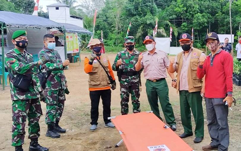 Kepala Pelaksana BPBD Damkar Barito Timur, Riza Rahmadi (dua dari kanan) saat menyerahkan bantuan di pos PPKM Mikro Desa Simpang Naneng.