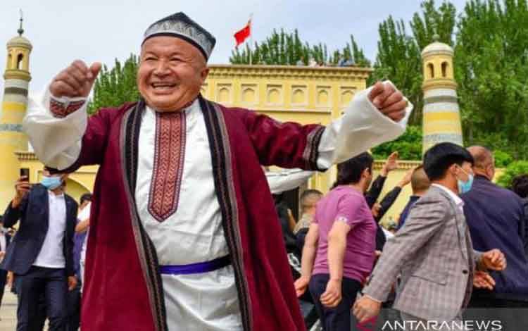 Warga etnis minoritas Muslim Uighur menari bersama merayakan Idul Fitri di halaman Masjid Idkah, Kota Kashgar, Daerah Otonomi Xinjiang, China, pada Kamis (13/5/2021)