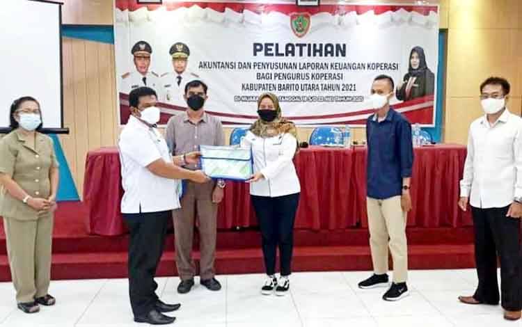 Kepala Disnakertranskop dan UKM Barito Utara M Mastur menyerahkan materi pelatihan kepada peserta secara simbolis saat pembukaan kegiatan
