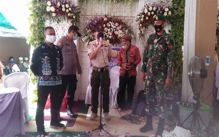Petugas gabungan saat memberikan imbauan penerapan protokol kesehatan diacara pernikahan warga, Kamis 20 Mei 2021