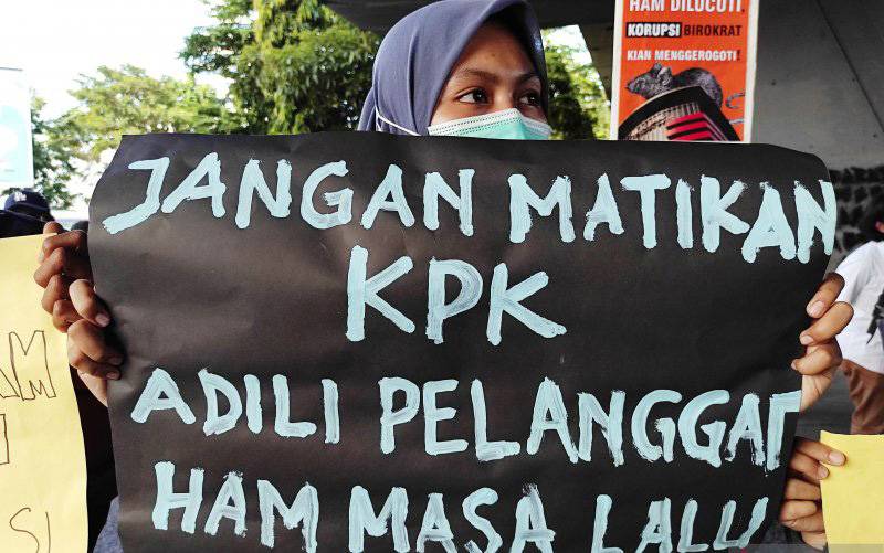 Peserta aksi memegang spanduk saat unjuk rasa terhadap pelemahan KPK di bawah jembatan layang, Makassar, Sulawesi Selatan, Jumat (21/5/2021). (foto : ANTARA/Darwin Fatir)