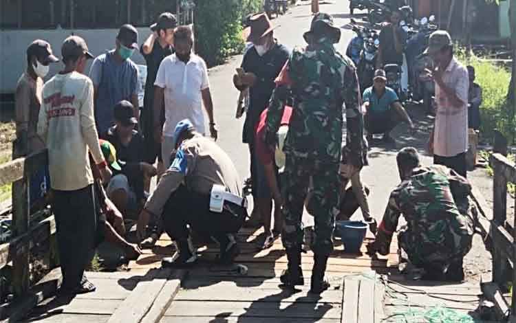 Anggota Polsek Pulau Petak Ikuti Gotong Royong Perbaiki Jembatan