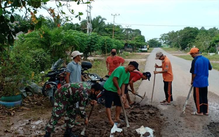 TNI Bersama Masyarakat Gotong Royong Tambal Jalan Berlubang