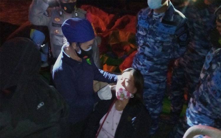 Petugas mengambil cairan hidung untuk melakukan tes antigen kepada warga yang kedapatan tidak menggunakan masker di Kawasan Bundaran Pancasila, Pangkalan Bun, Sabtu malam, 29 Mei 2021