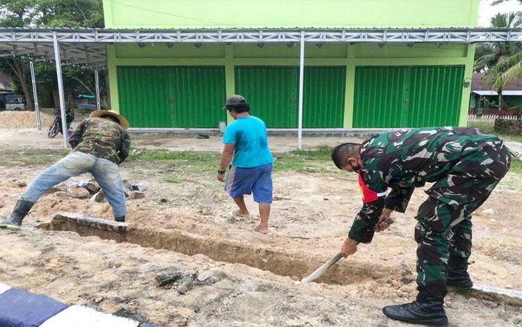 Babinsa 1013-01 Kandui bersama warga saat membuat drainase lingkungan