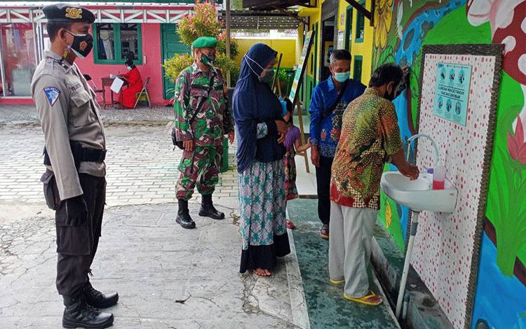 Babinsa Bersama Bhabinkamtibmas Mendawai Terus Konsisten Awasi Pelaksanaan PPKM Mikro