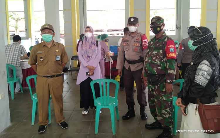 Babinsa Kelurahan Palangka Serda Sunardi saat mengawal vaksinasi