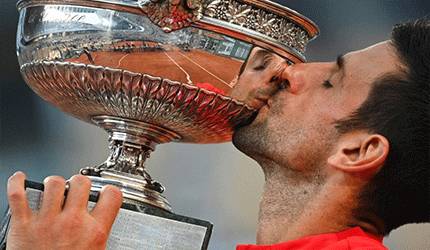 Petenis Serbia Novak Djokovic mencium Piala The Mousquetaires Cup setelah menaklukkan petenis Yunani Stefanos Tsitsipas dalam final French Open di Roland Garros, Paris, 13 Juni 2021. (ANTARA/AFP/Anne-Christine Poujoulat)